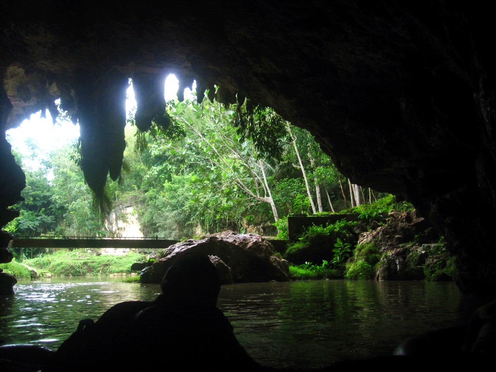 aFoto aktivitas cave tubing di Goa Pindul dari sudut atas, menampilkan cahaya alami masuk dari mulut gua